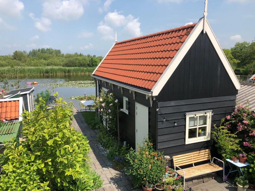 WestzaanHet Pulletje的湖畔红屋顶黑房子