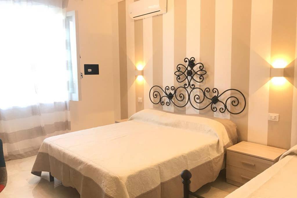 特罗佩阿Appartamento VistaMare的卧室配有白色的床和条纹墙