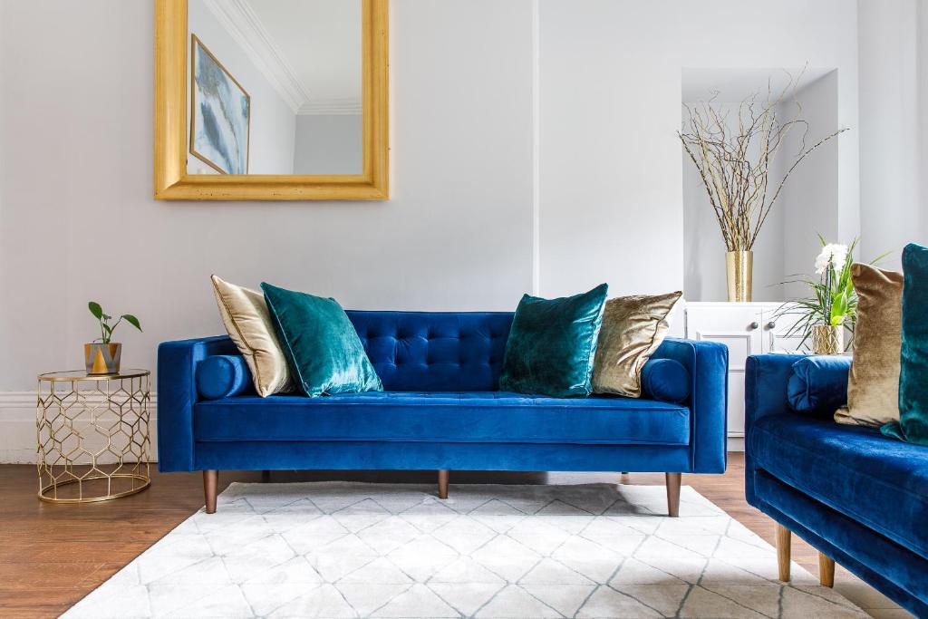 泰恩河畔纽卡斯尔Stylish Apartment in the heart of Newcastle centre的客厅配有带枕头的蓝色沙发