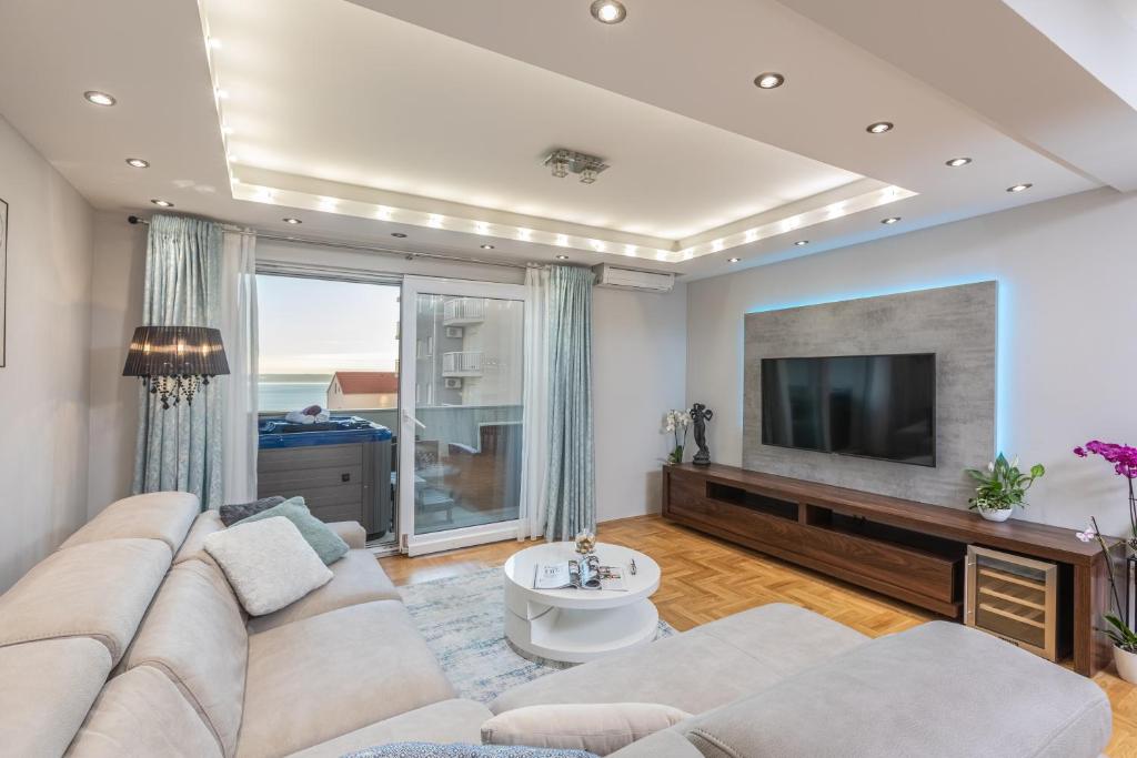 马卡尔斯卡Luxury apartman SKY with sea view and whirlpool的客厅设有大沙发和电视