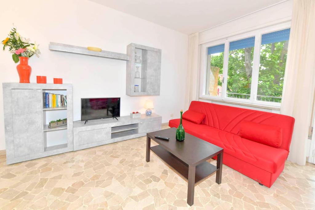 威尼斯丽都Appartamento Lido Mare的客厅配有红色沙发和电视