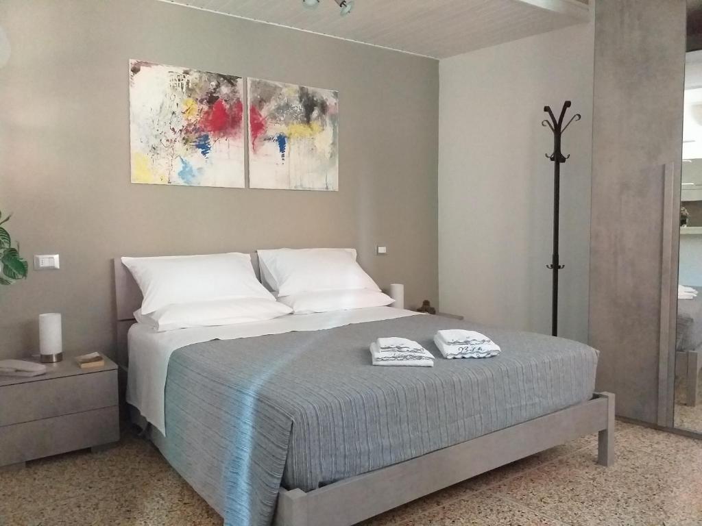 博洛尼亚L'Appartamentino的卧室配有一张床,墙上挂有绘画作品