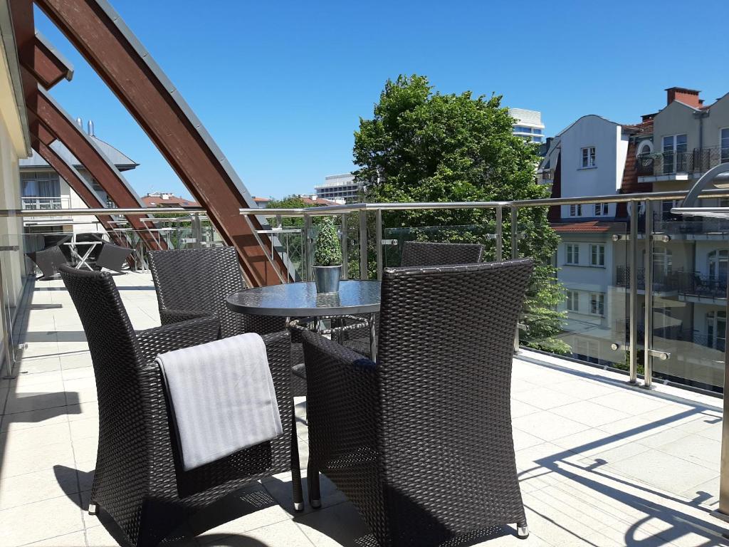 斯维诺乌伊希切Apartament LAPIS Panorama Avangard的阳台的天井配有桌椅