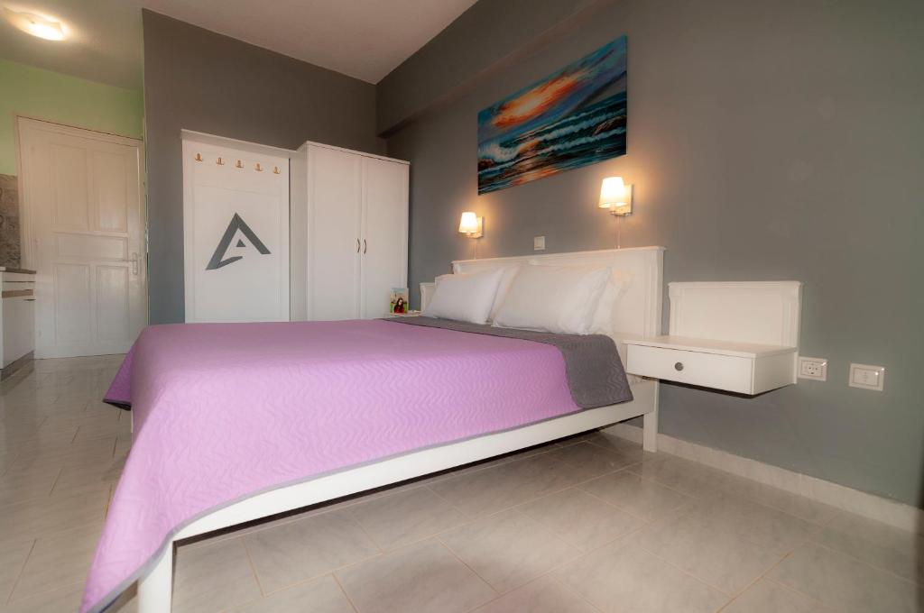 阿尔卡萨阿尔法一室公寓的一间卧室配有一张大床和紫色毯子