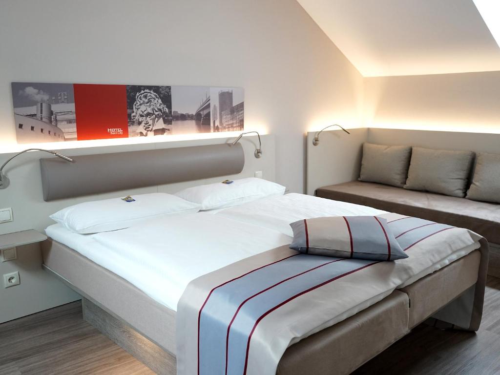 波恩波恩城市酒店的一间卧室配有一张大床和一张沙发