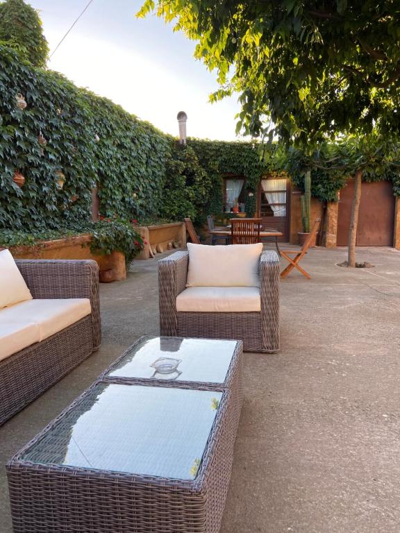 佩雷拉达Turisme rural Can Genis的庭院配有2把藤椅和桌子