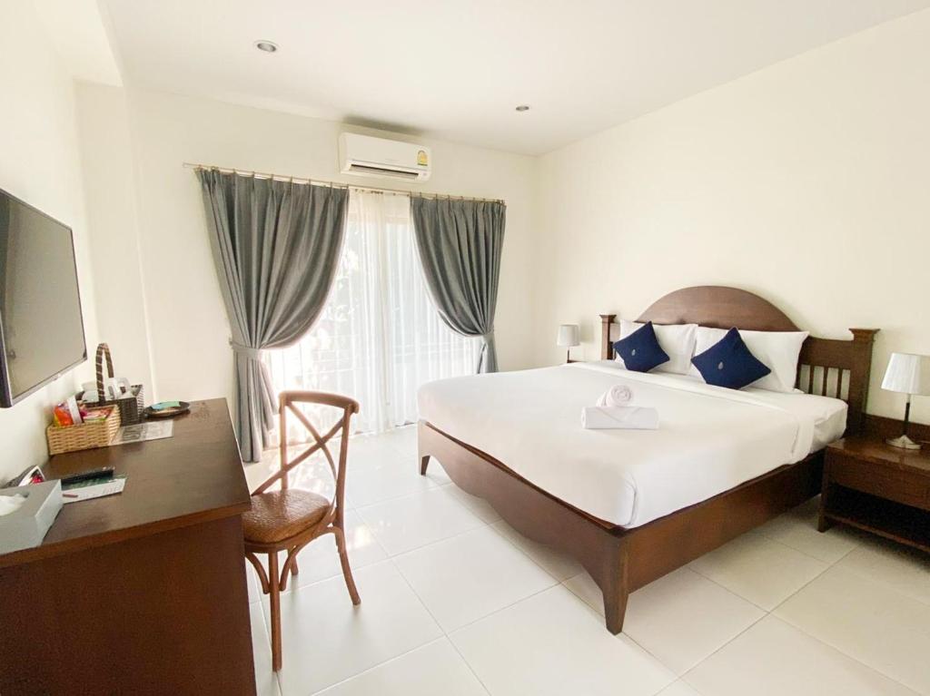 呵叻库拉纳瑞庭院精品酒店的酒店客房配有一张床、一张书桌和一台电视。