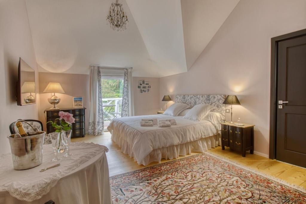 勒图凯-巴黎普拉日Villa Vent-Couvert的一间卧室配有一张大床和一张桌子及四柱床