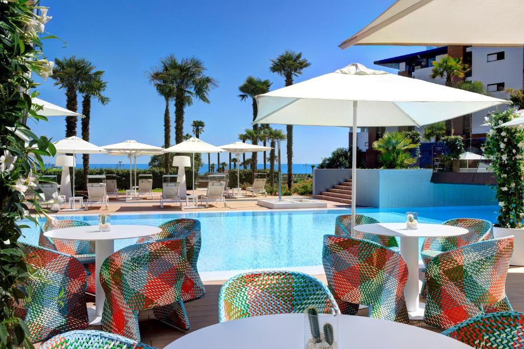 利多迪耶索罗奥尔马尔索洛Spa度假酒店的享有带桌子和遮阳伞的游泳池景色