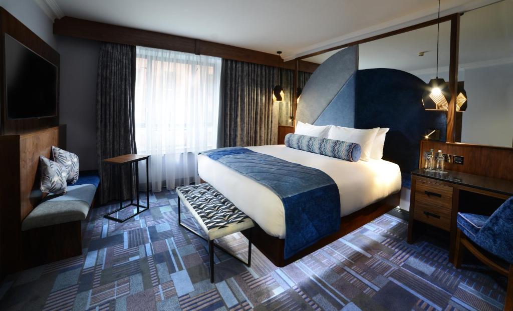 都柏林Arthaus Hotel的酒店客房带一张大床和一把椅子
