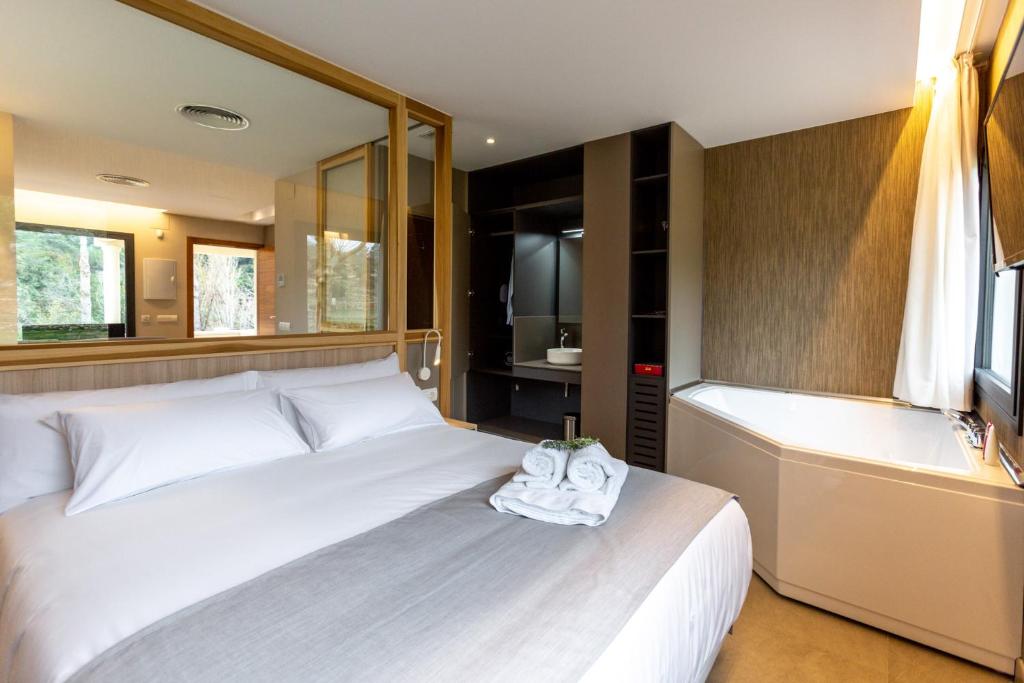 BallestarSant Pere Homes的卧室配有白色的床和浴缸