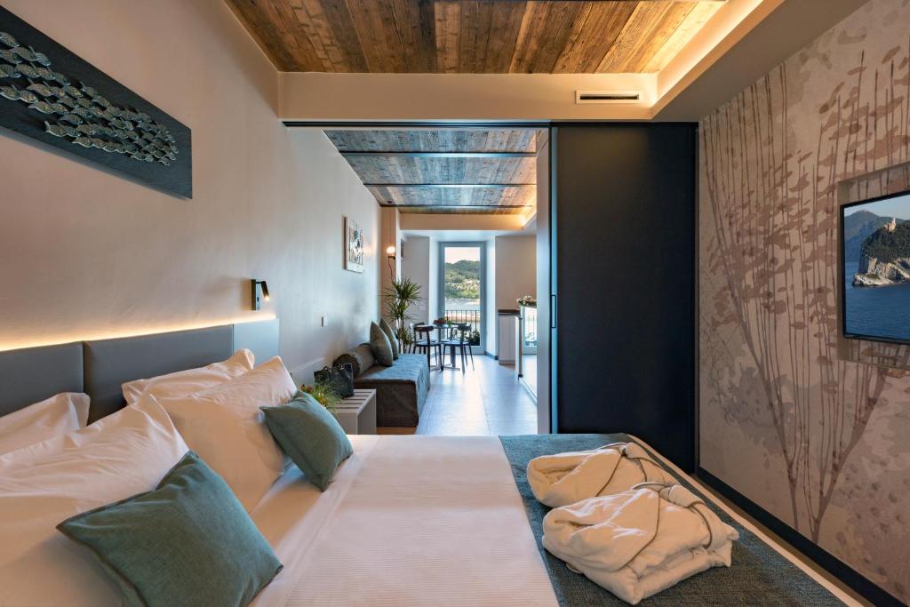韦内雷港Al Gabbiano "Suite"的一间带大床的卧室和一间客厅