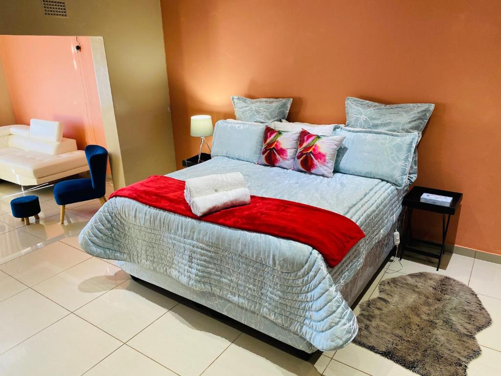 ButterworthRiver Valley Guest House的一间卧室配有一张带色彩缤纷枕头的大床