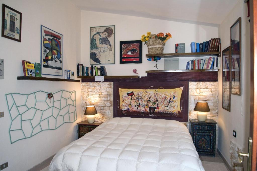 奥尔比亚Guesthouse Nuvole的一间卧室配有一张床和两盏灯及书籍