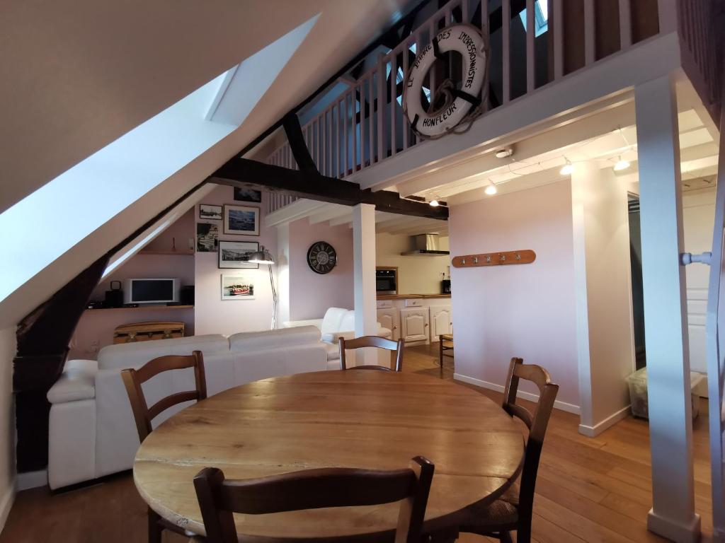翁弗勒尔Phare des Impressionnistes的用餐室以及带桌椅的起居室。