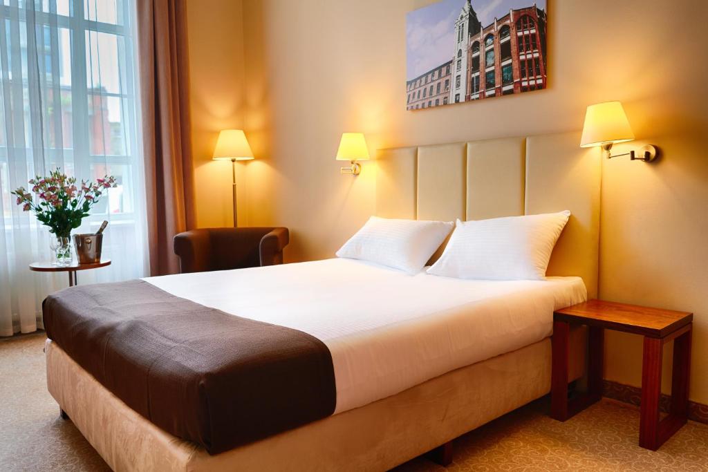 罗兹罗兹福克斯酒店的一间设有大床和窗户的酒店客房