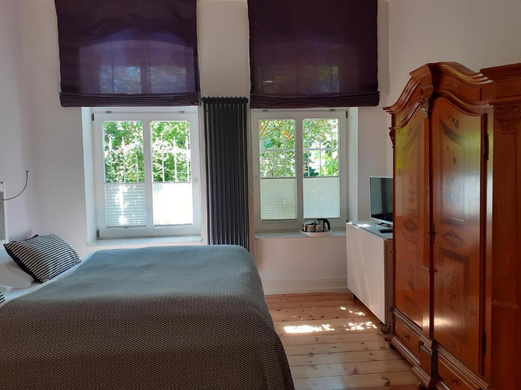 吕讷堡Villa Friedenstraße 11的一间卧室设有一张床和两个窗户。