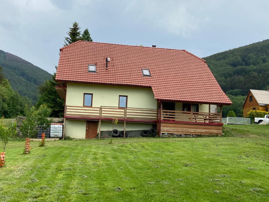 特罗亚诺维采Chalupa u Bártů的一座大房子,在田野上设有红色屋顶