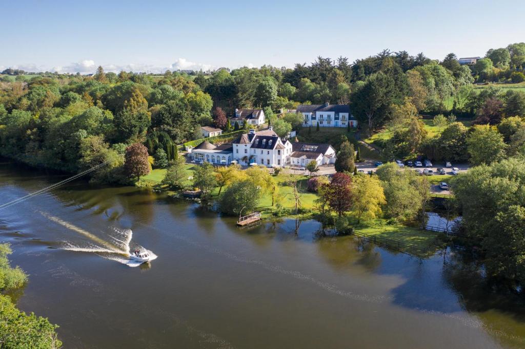 InishannonInnishannon House Hotel的河上房屋的空中景观,带船