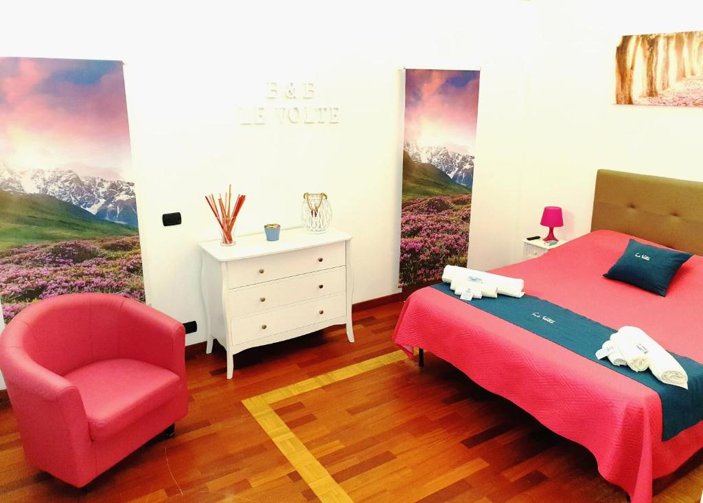 卡斯泰拉内塔B&B Le Volte的一间卧室配有红色的床和椅子