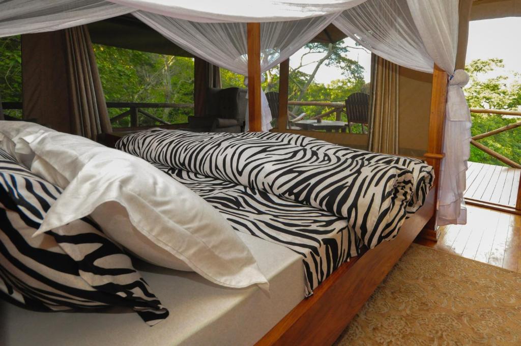 阿鲁沙卡拉马山林小屋的配有斑马纹床单的客房内的两张床