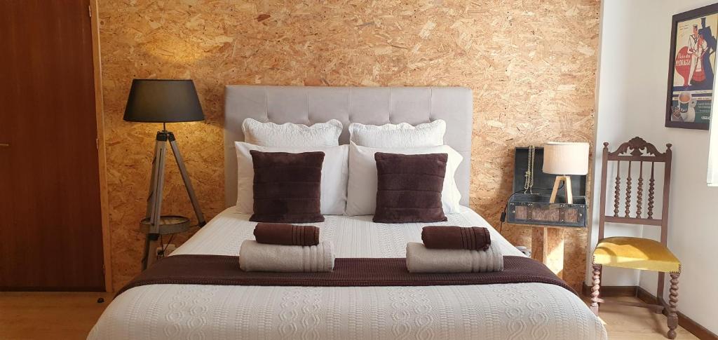 阿尔马达卡里亚蒂维®住宿加早餐旅馆的卧室配有带棕色枕头的大型白色床