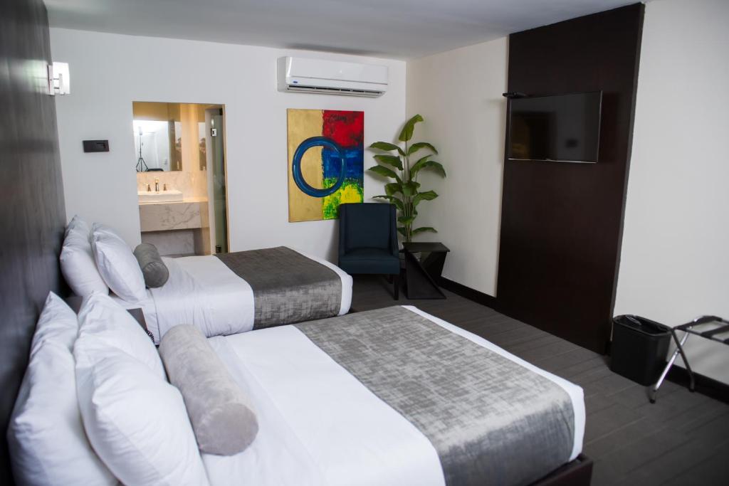 雷诺萨Stay Inn Hotels的酒店客房设有两张床和电视。