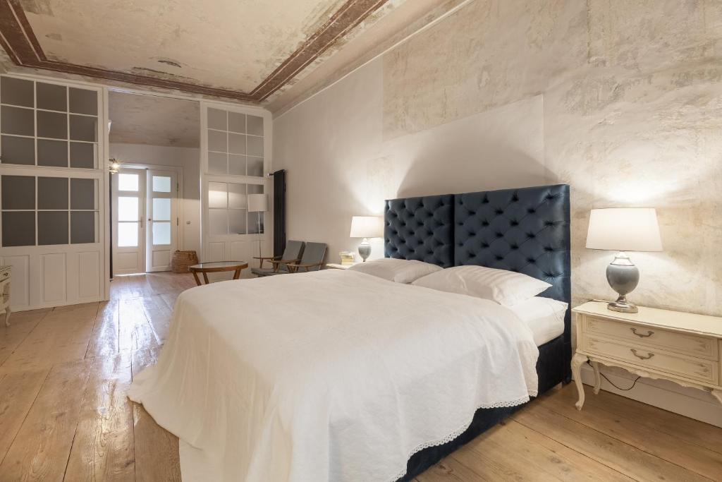 特尔纳瓦Apartments 1620yr Trnava的一间卧室配有一张白色大床和蓝色床头板