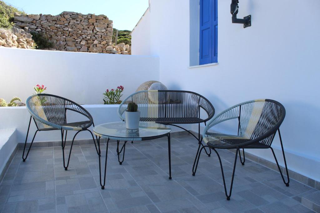 ArkesíniCycladic Villa in Amorgos Island (Maison Shiro)的庭院里设有三把椅子和一张桌子