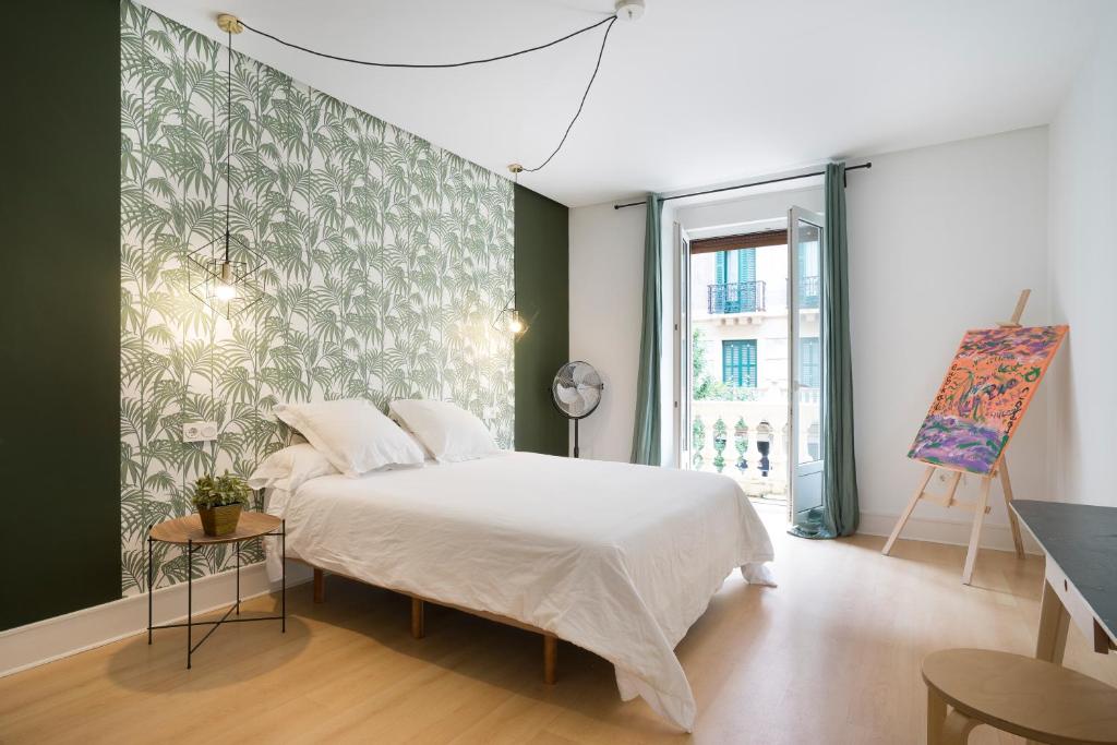 圣塞瓦斯蒂安Usandizaga Apartment, Second line beach, free Parking的卧室配有白色的床和绿色的墙壁