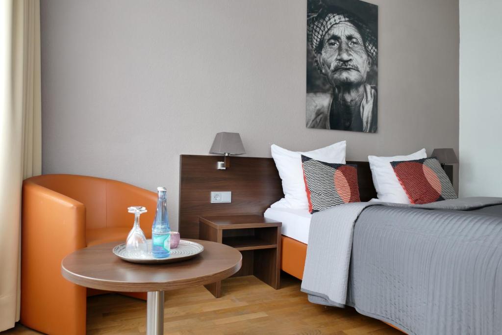 科隆DAS Steeps Ihr Brauhaus und Hotel的酒店客房设有一张床和一张桌子