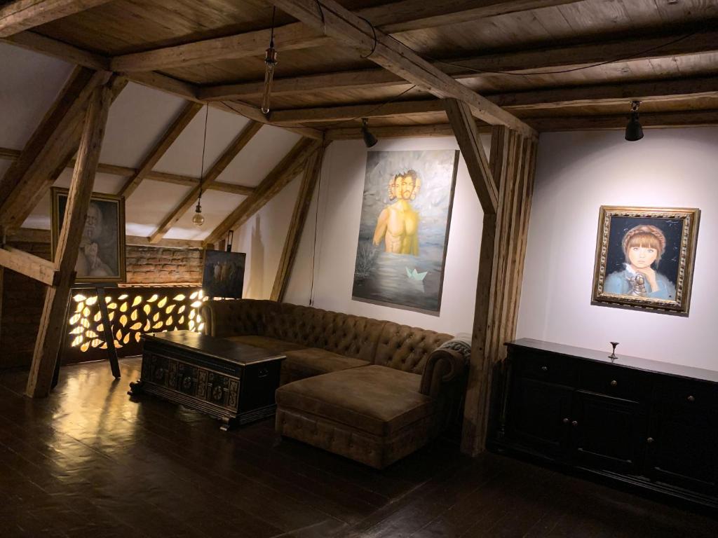 皮亚特拉-尼亚姆茨Gallery Loft的客厅配有沙发,墙上挂有绘画作品