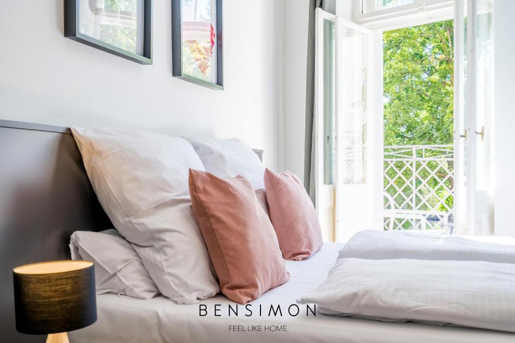 柏林BENSIMON apartments Prenzlauer Berg的白色的床、粉色和白色枕头以及窗户