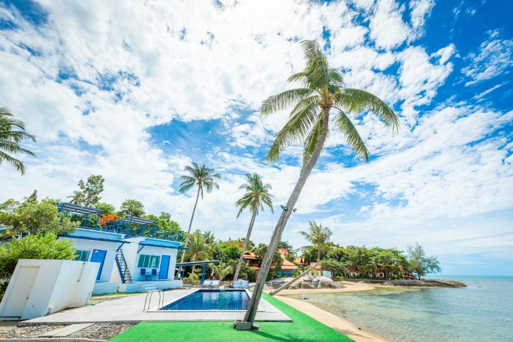拉迈苏梅岛沙罗查别墅三棵树度假酒店的毗邻大海的游泳池的棕榈树