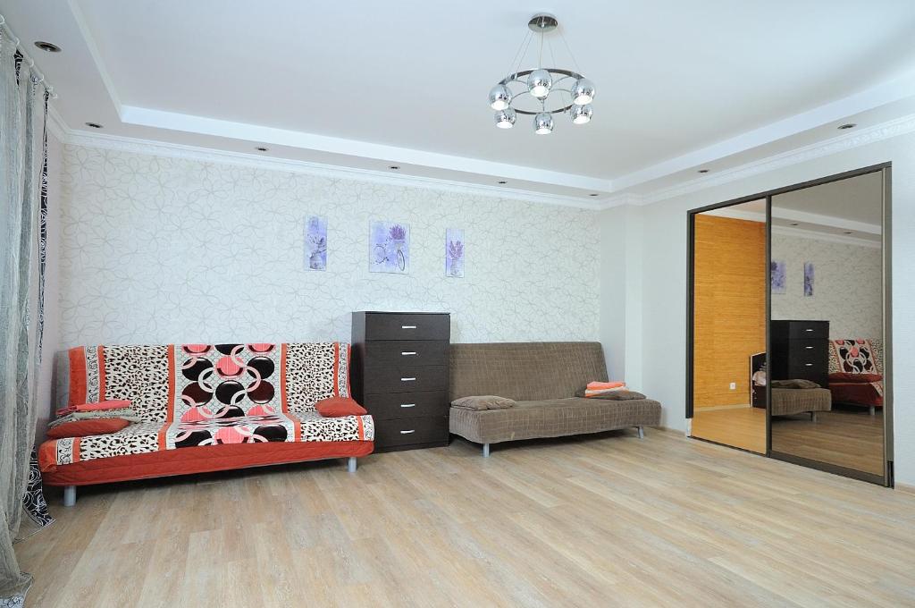 鄂木斯克Omsk Sutki Apartment on 70 let octyabrya 10/3的带沙发和镜子的客厅