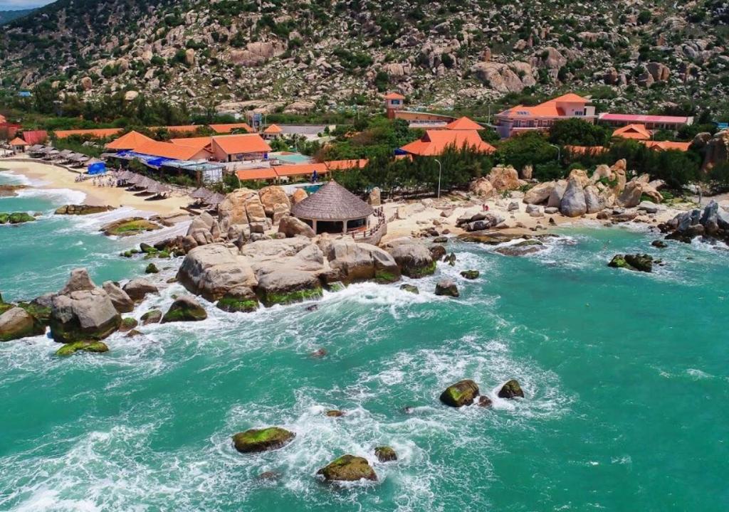 Thôn Lạc NghiệpHòn Cò Resort - Cà Ná的享有海滩的空中景色,在水中岩石