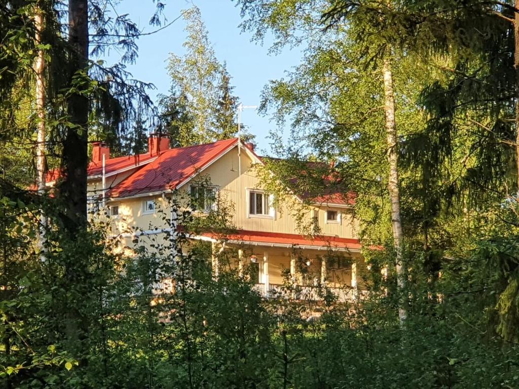 Kannuskoski图汉能陶瑞纳塔洛酒店的一座有红屋顶的房屋,透过树林