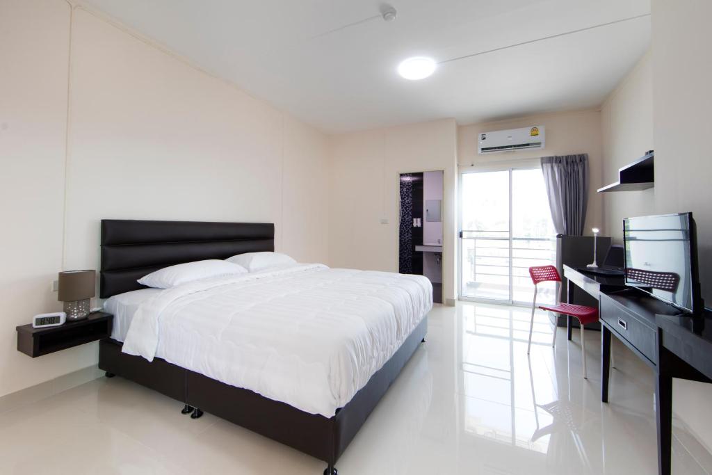 Pluak DaengJJ Residence的一间卧室配有一张床、一张书桌和一台电视