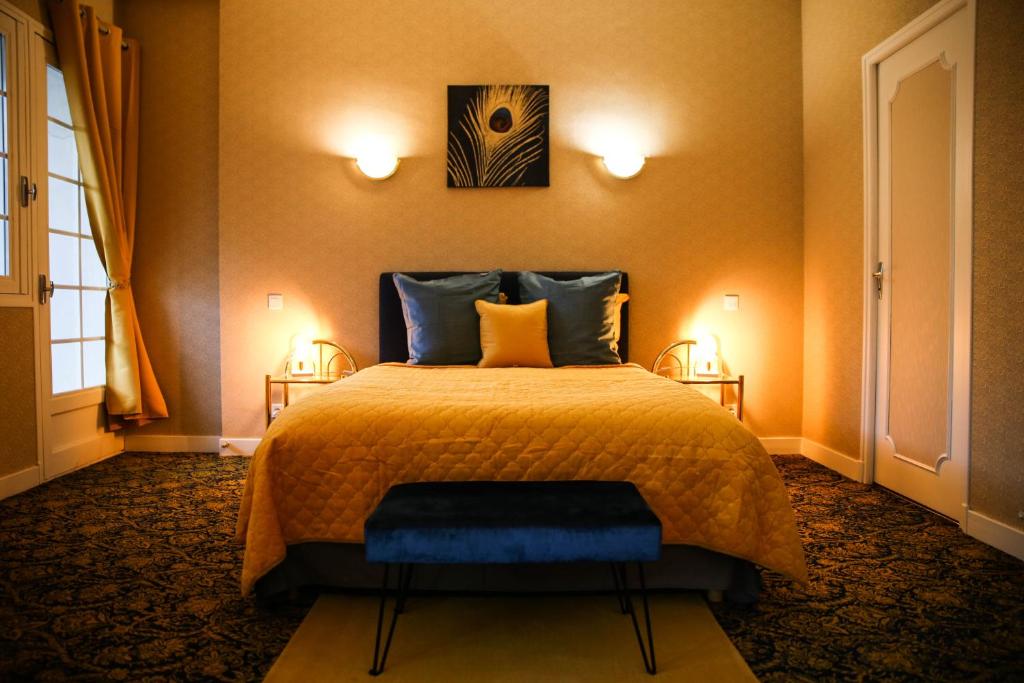 瓦朗赛Aux Portes du Château的卧室配有一张床,墙上有两盏灯