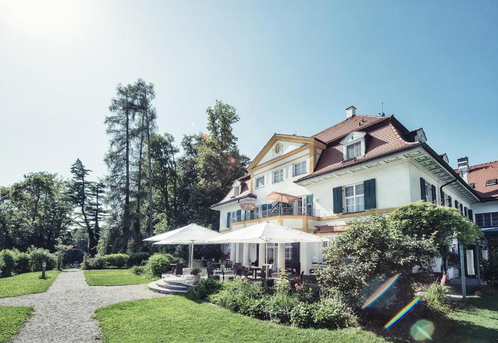 明辛奥贝姆巴赫城堡拜尔酒店的一座大白色房子,在院子里放伞