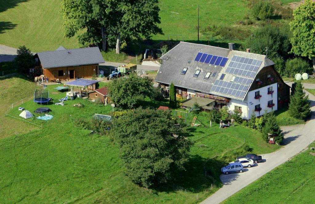 黑林山区圣格奥尔根菲尔恩霍夫格达酒店的享有房子的空中景色,上面设有太阳能电池板