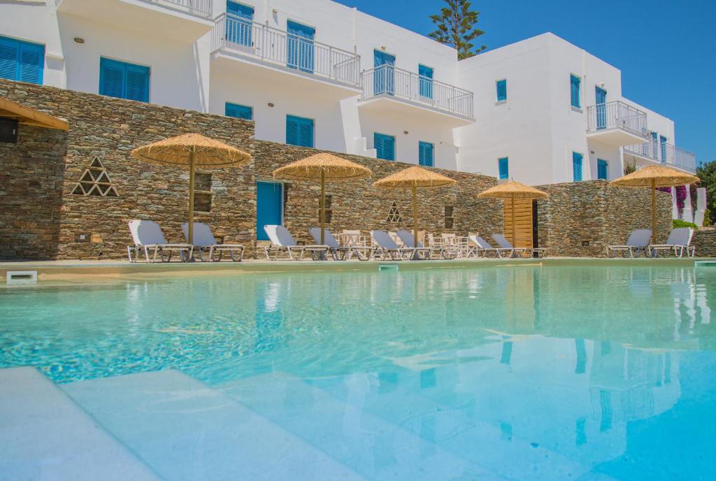 加夫里翁奥斯特里亚公寓酒店的大楼前的游泳池配有椅子和遮阳伞