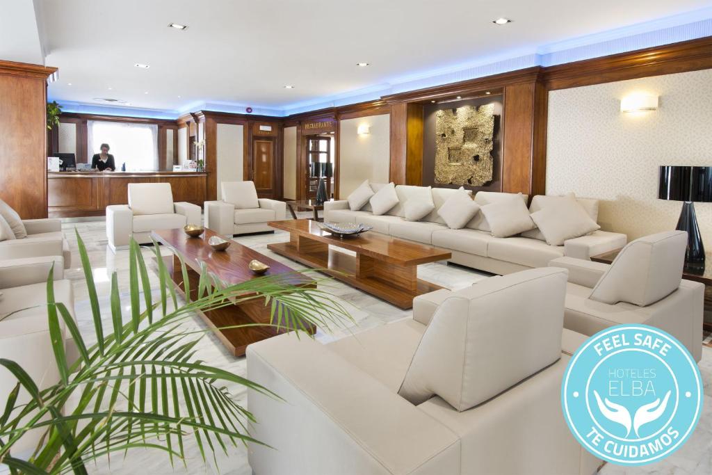 莫特里尔厄尔巴莫特里尔海滩商务酒店的客厅配有白色的沙发和桌子