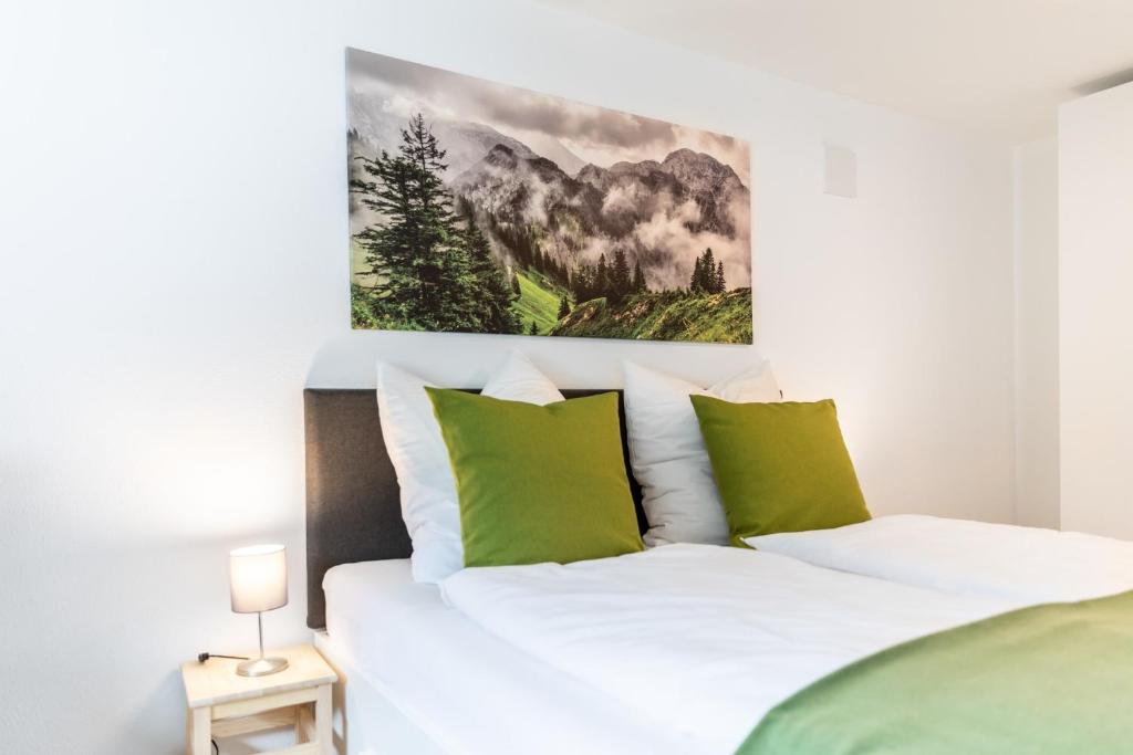 旧天鹅堡Chalet Annemarie Hohenschwangau的一间卧室配有带绿色和白色枕头的床