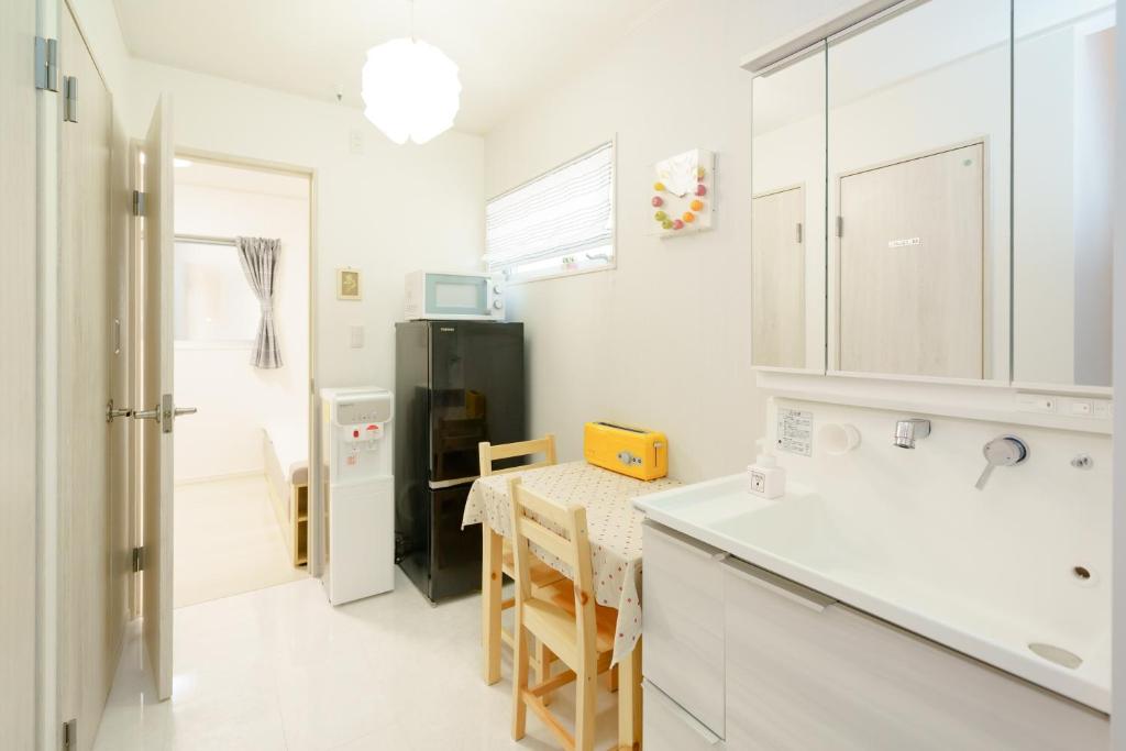 大阪Osaka Yeon House的厨房配有桌子和黑冰箱。