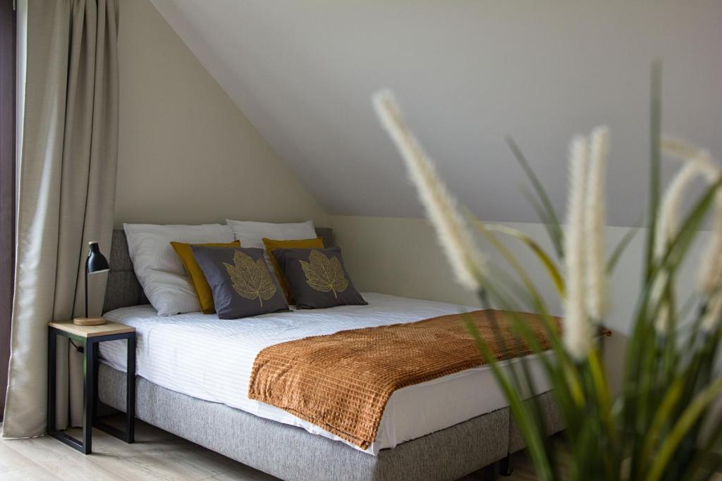 瓦多维采Barwald Hills的一间卧室配有带枕头和植物的床
