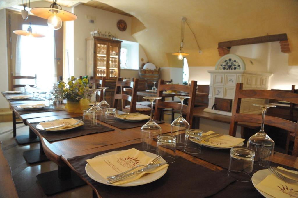 Rivoli Veronese索尔德蒙塔尔托农家乐的用餐室配有带玻璃杯的长木桌