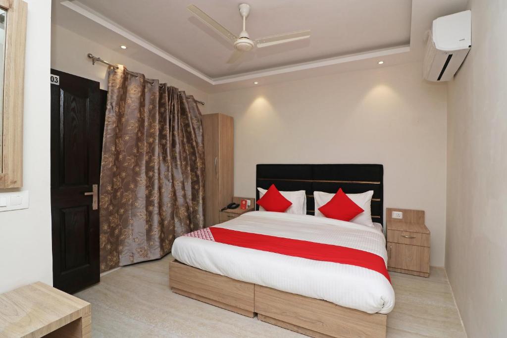 孟买Hotel Delight的一间卧室配有一张带红色枕头的大床