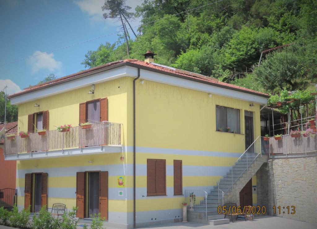 韦扎诺利古雷AMICI Holiday B&B di Bielak Aneta Izabela的带阳台和楼梯的黄色房屋