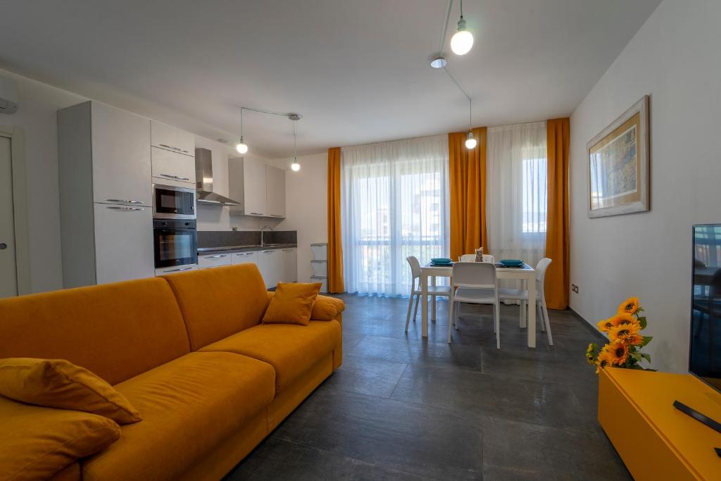 福洛尼卡La Luna nel Golfo - Appartamenti a Follonica的一间带黄色沙发的客厅和一间厨房